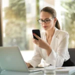 Digital distraction with phone buzzing beside person at desk